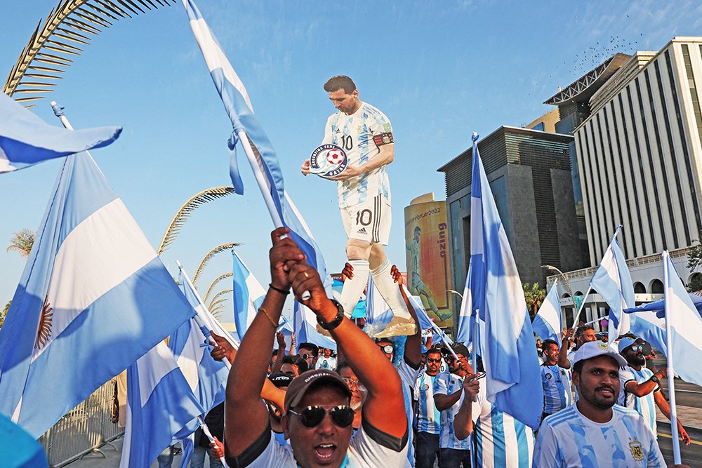 Столица Катара Доха сегодня. Аргентинские болельщики бродят по улицам, таская с собой огромную картонную фигуру своего кумира Лионеля Месси. / REUTERS